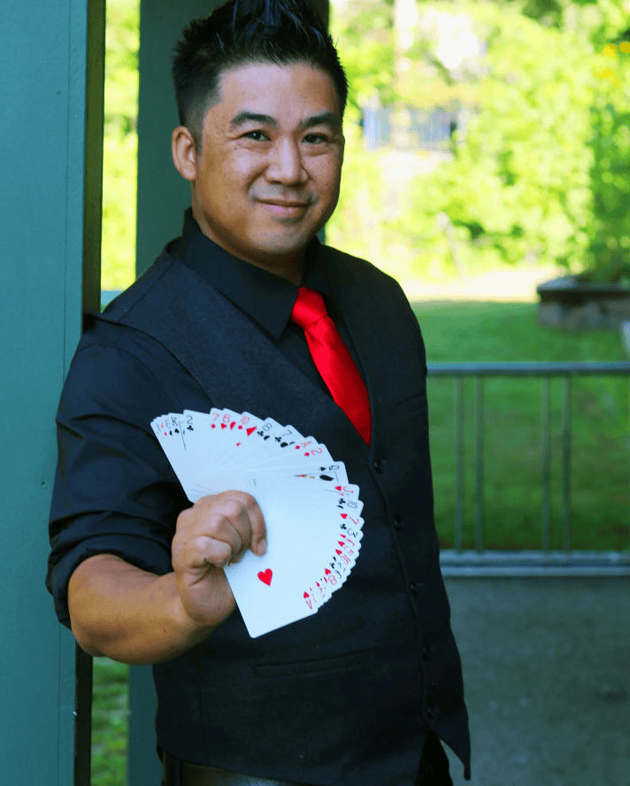 Magician Norman Ng holding fanned out cards
