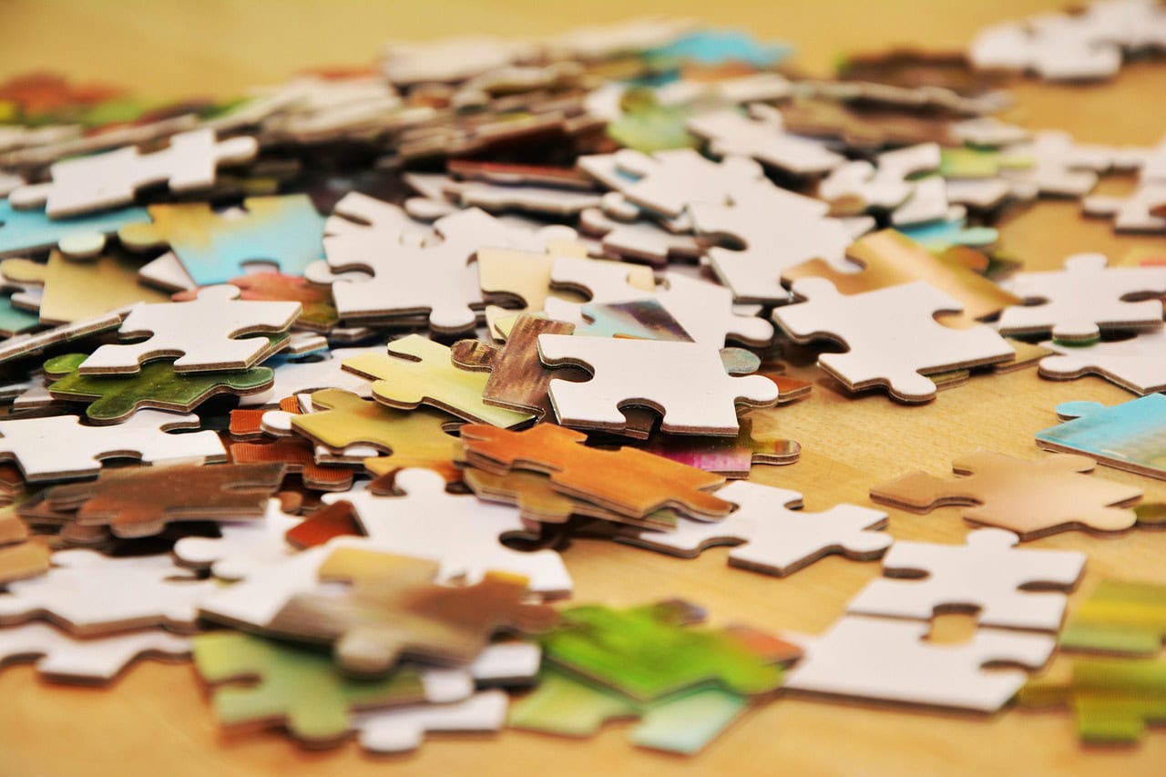 Close up of multi-color puzzle pieces on a wooden table